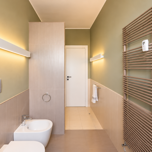 Bagno moderno illuminato con radiatore scaldasalviette