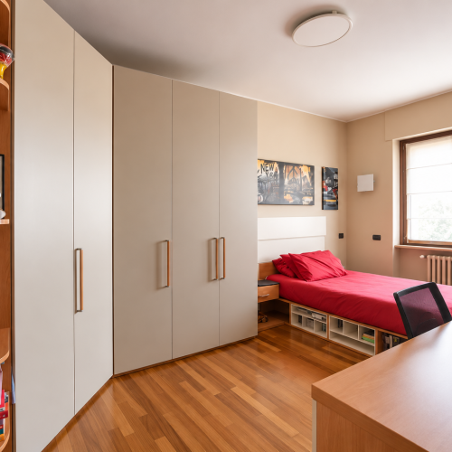 Camera da letto minimalista con studio e letto rosso