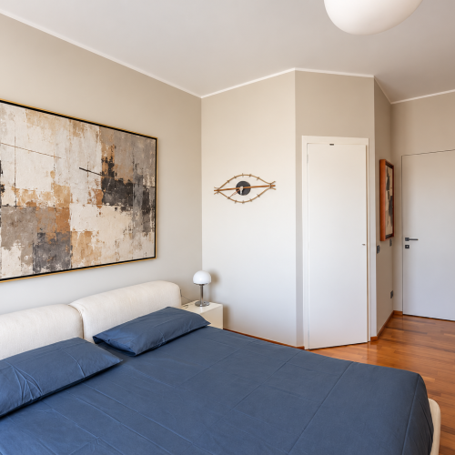 Camera da letto moderna con arte astratta neutra