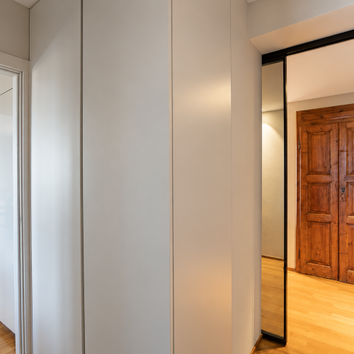 Corridoio moderno tra cucina e porta in legno
